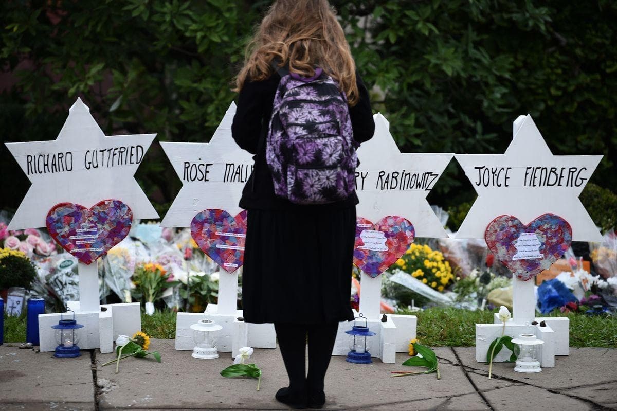 Sur cette image : une personne se recueille devant une synagogue, à Pittsburgh, à la suite d’une tuerie ayant fait 11 morts.