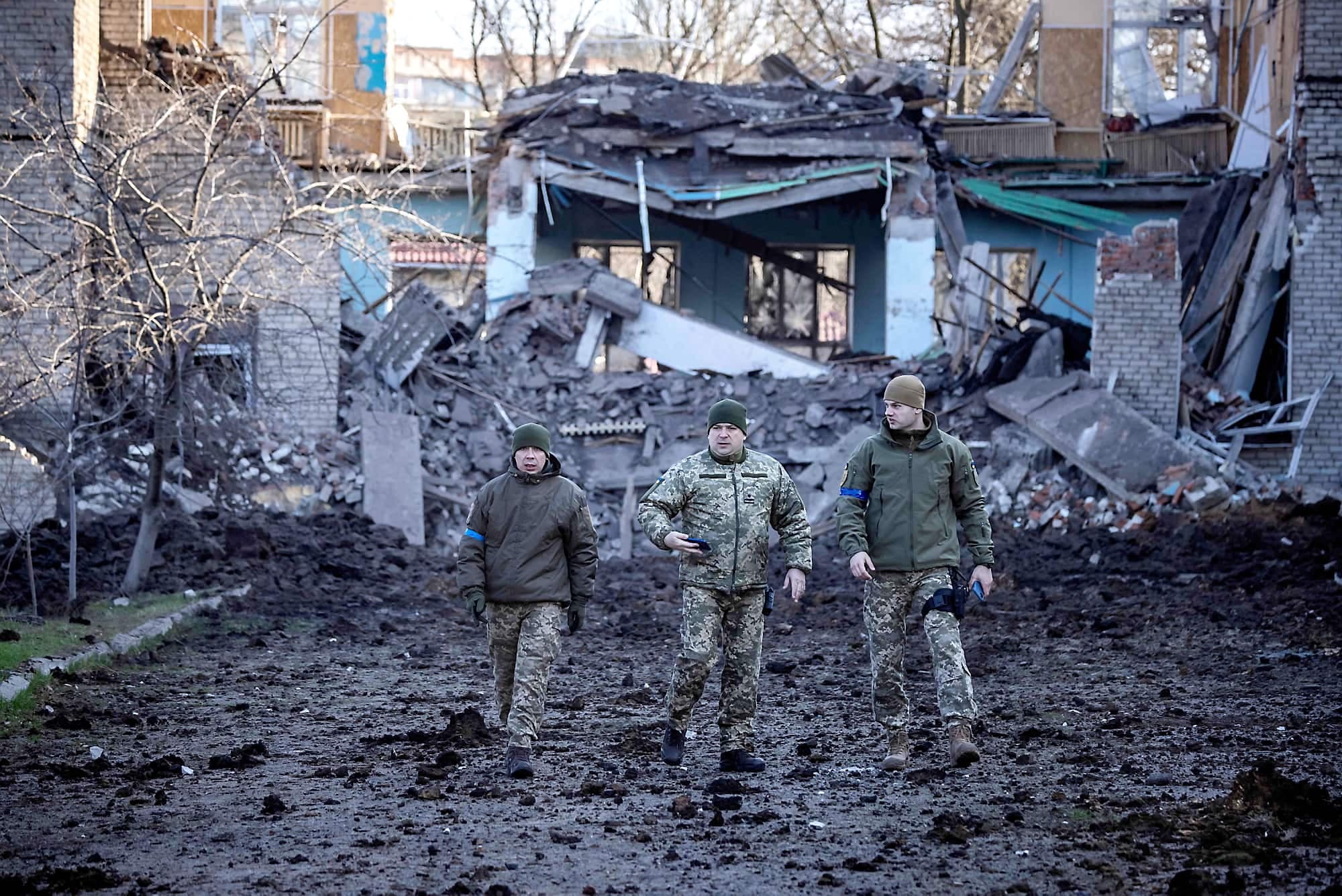 Des militaires de l’Ukraine marchent près d’une école endommagée, à côté d’un bâtiment de la police à Kramatorsk, dans la région du Donbas, dans l’est de l’Ukraine.