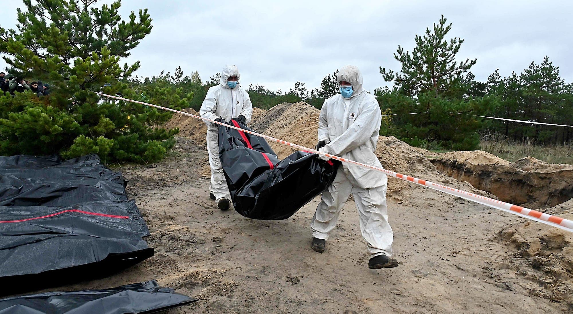 Des experts transportaient mardi à Lyman une des 44 personnes enterrées dans une fosse commune.
