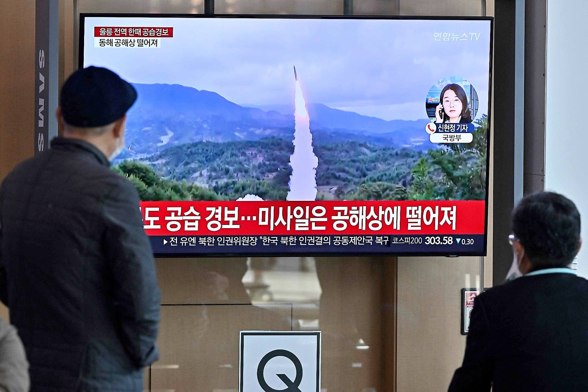 Des gens dans une gare à Séoul regardent des images d’archives d’un essai de missile nord-coréen.