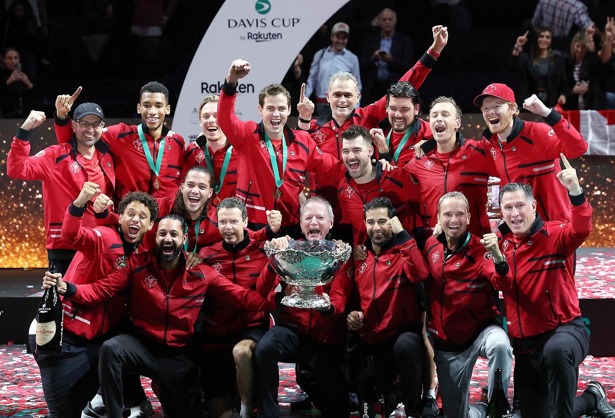 On peut voir de larges sourires dans les visages des membres de l’équipe du Canada, qui célèbre avec la Coupe Davis et du champagne.