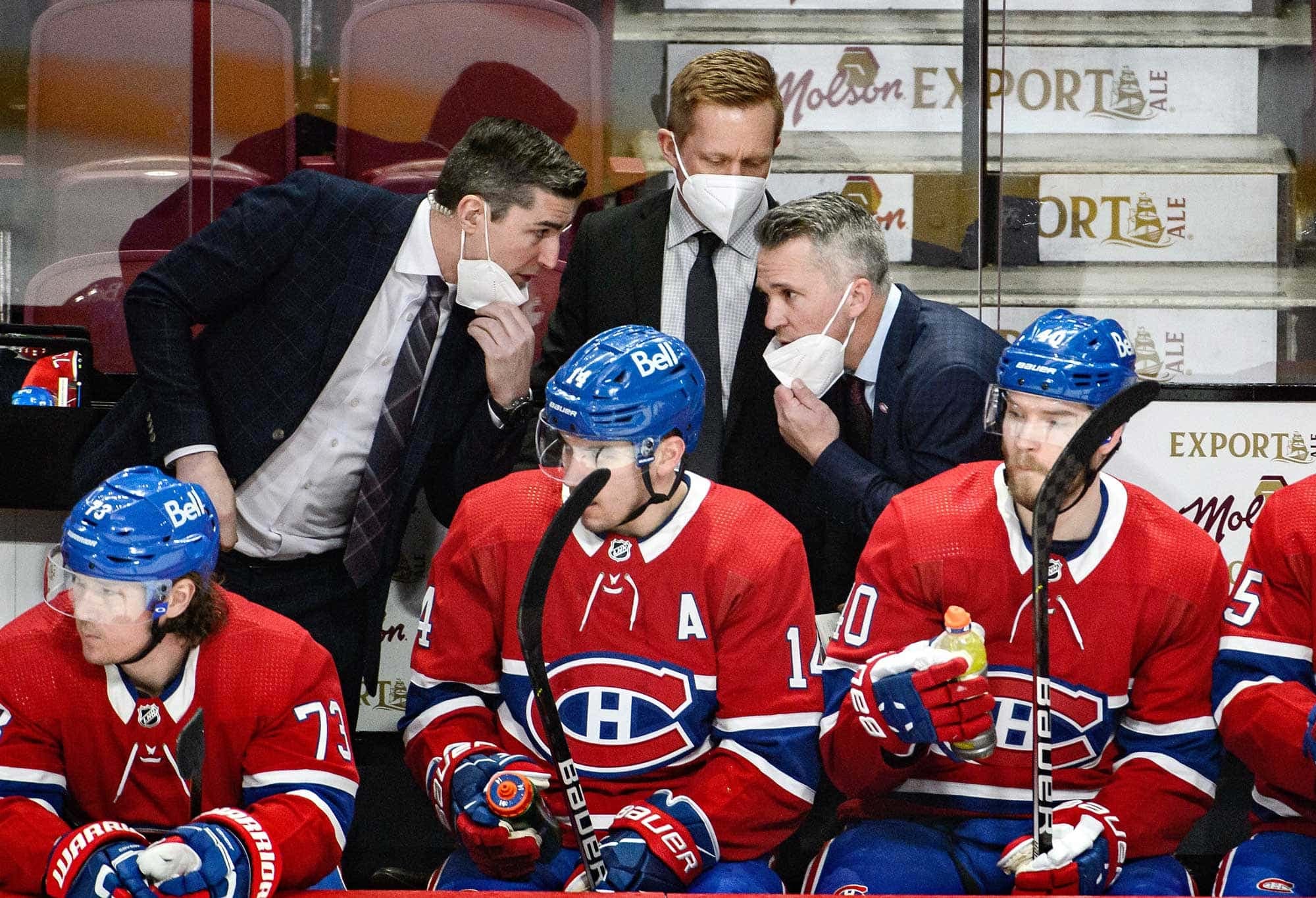 Les entraîneurs Alex Burrows et Martin St-Louis en pleine discussion sous le regard de Trevor Letowski.