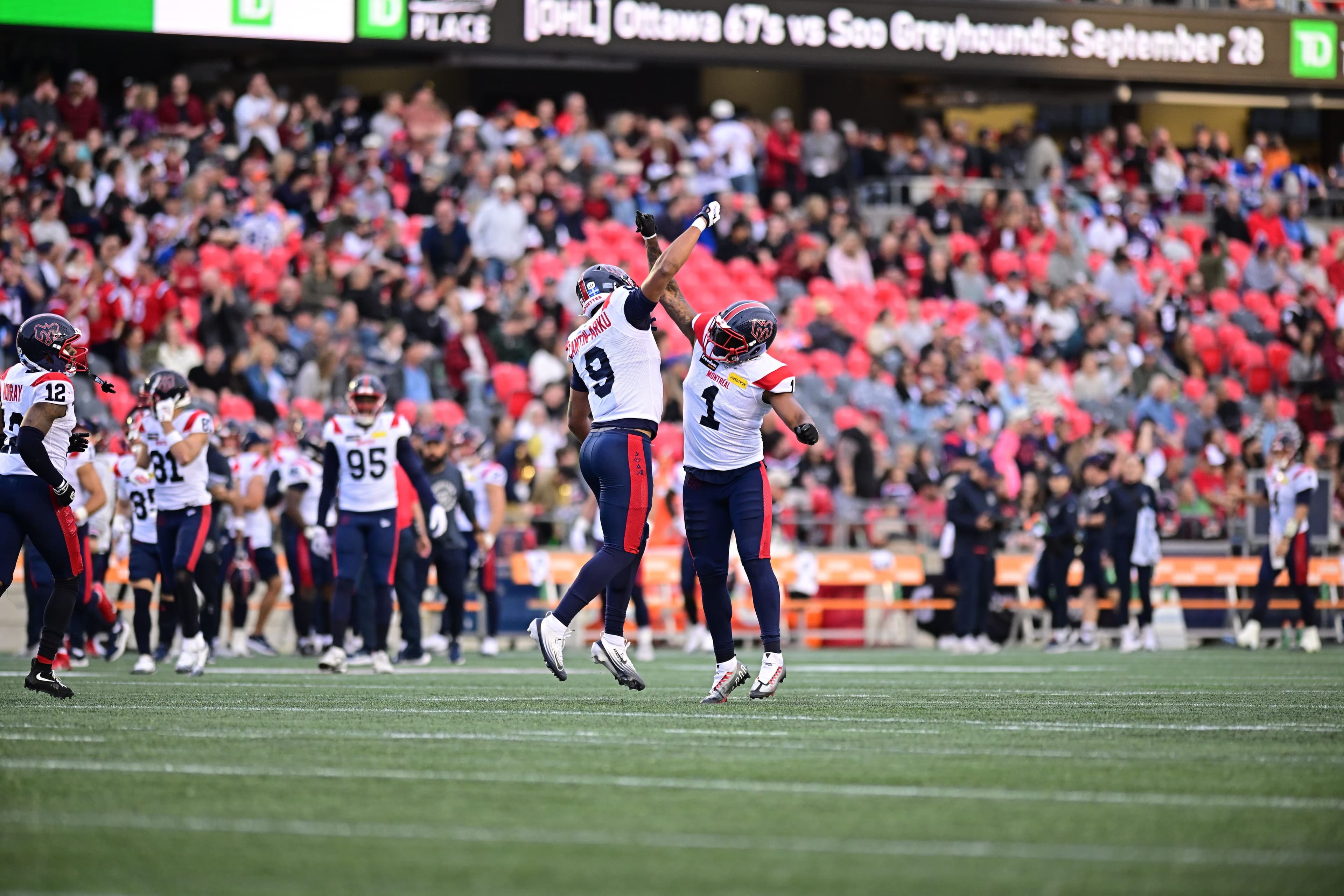 Geoffrey Cantin-Arku et Darnell Sankey, membres de l'unité défensive des Alouettes, célèbrent durant le match contre le Rouge et Noir, le vendredi 13 juin, à Ottawa.