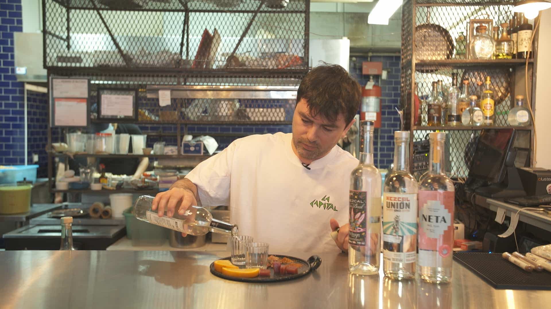 Geoffrey Moreau, propriétaire du restaurant La Capital à Montréal, prépare une assiette de dégustation de mezcals agrémentée de sauterelles et de sels d'insectes.