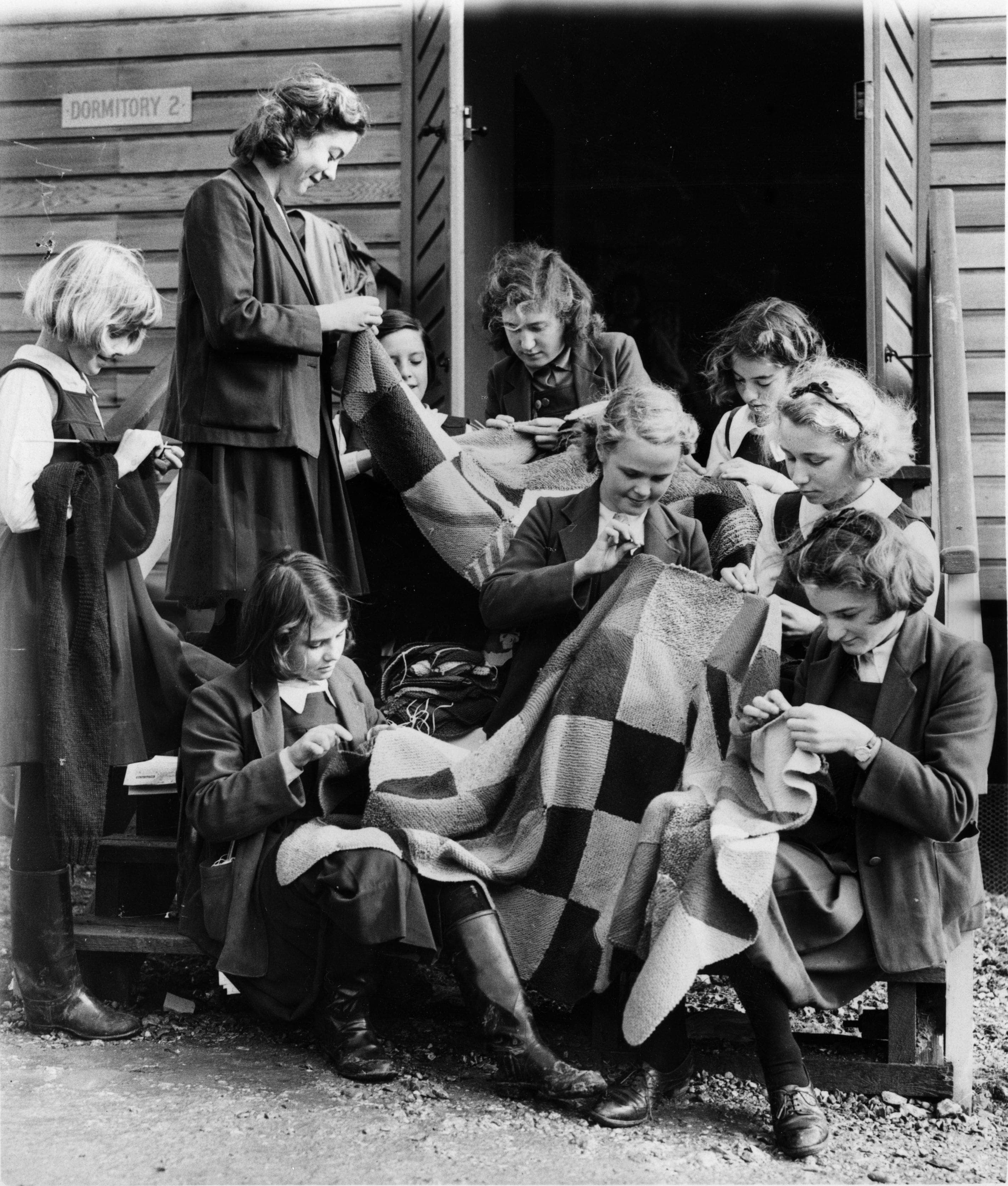 Un groupe de femmes évacuées de la Beal Modern School, à Kent, en 1940, réalisent une courtepointe pour les forces militaires.