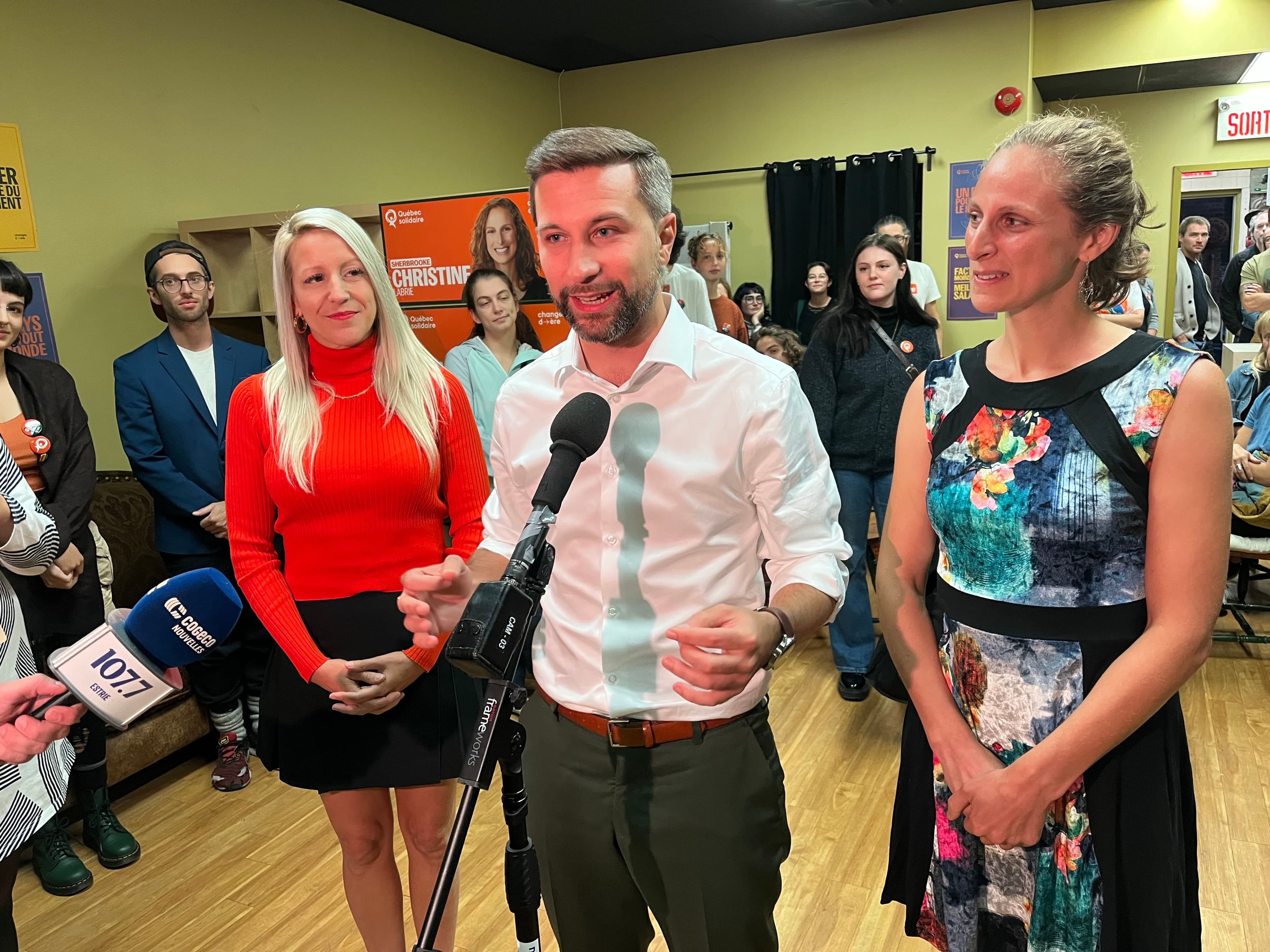 Le porte-parole solidaire Gabriel Nadeau-Dubois, lors d'une mêlée de presse samedi soir au local électoral de sa candidate Christine Labrie (à droite), avec sa candidate dans Saint-François, Mélissa Généreux.