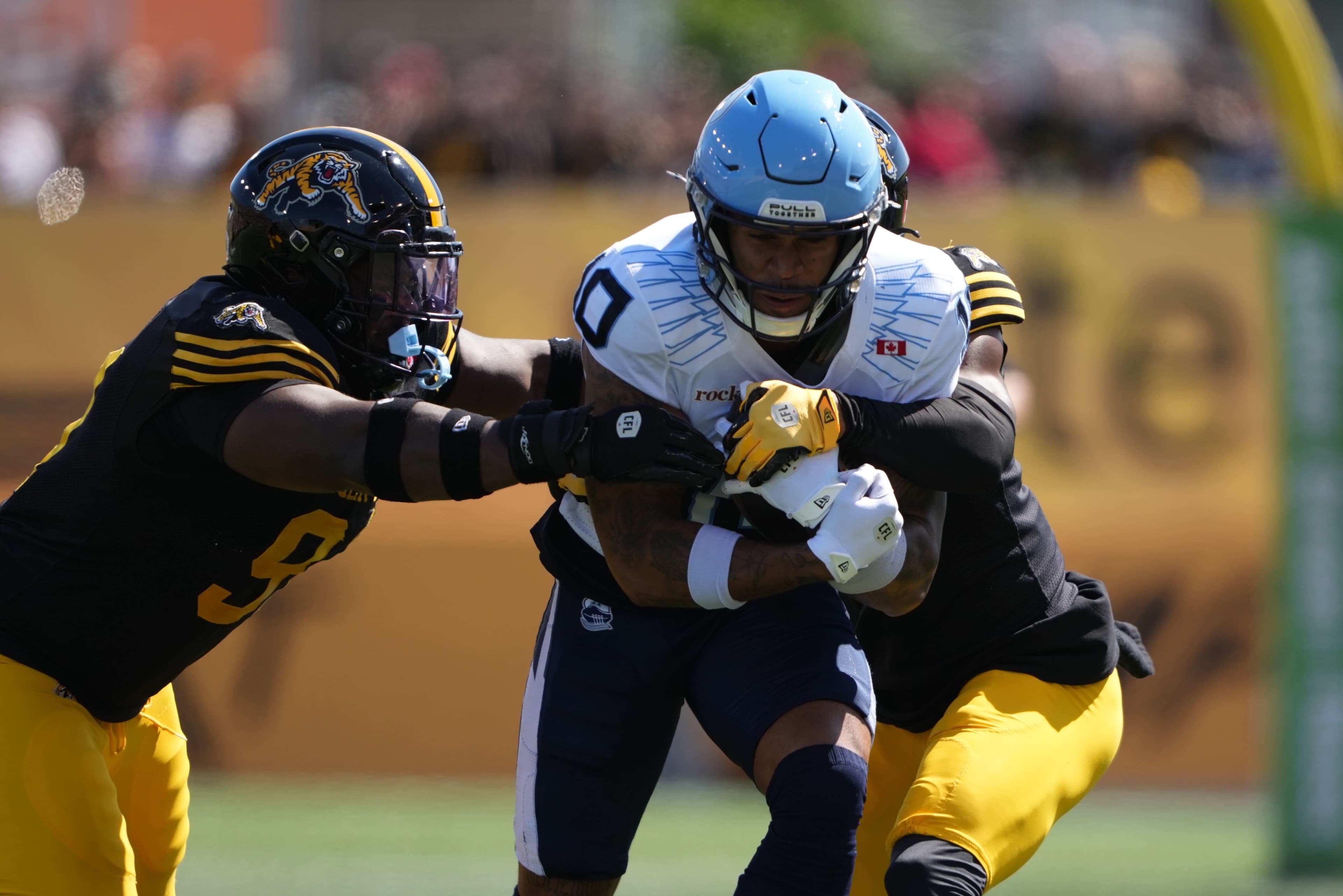 Le Québécois Kevin Mital, des Argonauts de Toronto, protège précieusement le ballon dans un match disputé contre les Tiger-Cats, le 1er septembre 2025, à Hamilton.