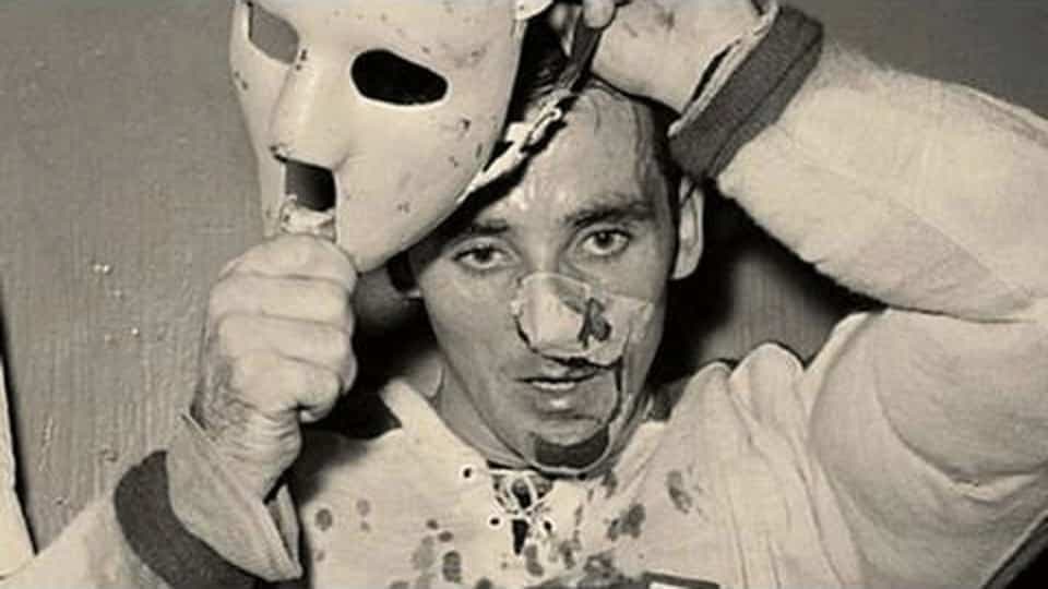 Jacques Plante, le 1er novembre 1959. Le gardien des Canadiens s’effondre sur la glace, le visage ensanglanté. Il quitte la patinoire pour se faire recoudre une partie du visage. À ce moment de sa carrière, Jacques Plante compte sept saisons dans la Ligue nationale et a déjà reçu au moins 150 points de suture à la figure.