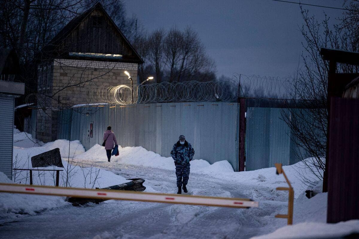 Un officier du Service fédéral russe des pénitenciers marche près de la porte de la colonie pénitentiaire dans la ville de Pokrov