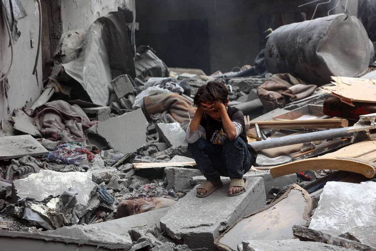 Un garçon palestinien s’accroupit sur les décombres d’un quartier résidentiel de Shujaiyya à Gaza, bombardé par Israël, le 9 avril 2025. Une partie des dons d’Americares, visée par l’administration Trump, est destinée à l’aide des Palestiniens.