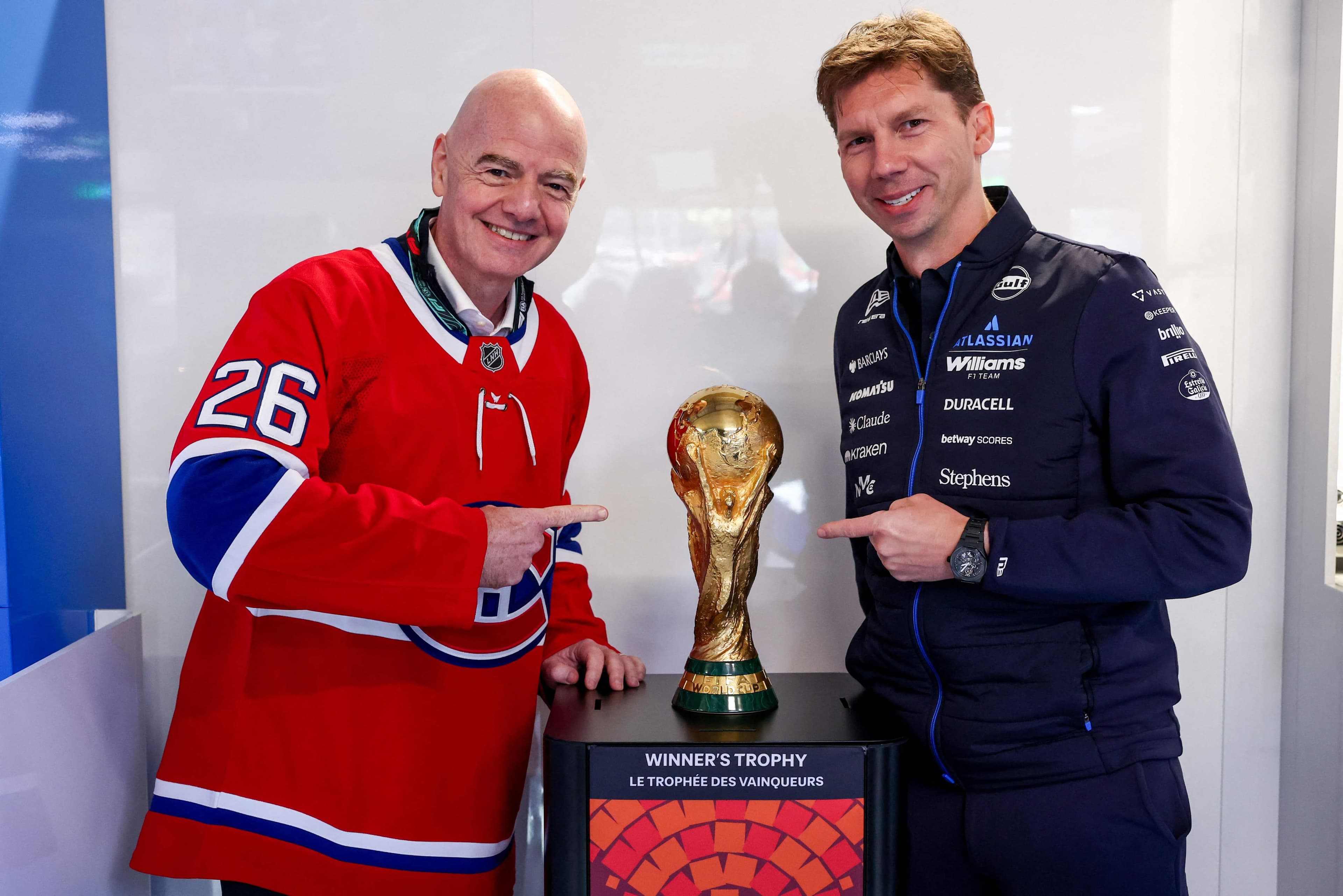 Le président de la FIFA, Gianni Infantino, et le directeur de l'écurie Williams, James Vowles, posent avec le trophée de la Coupe du monde de soccer, dimanche, au Grand Prix de F1 du Canada.