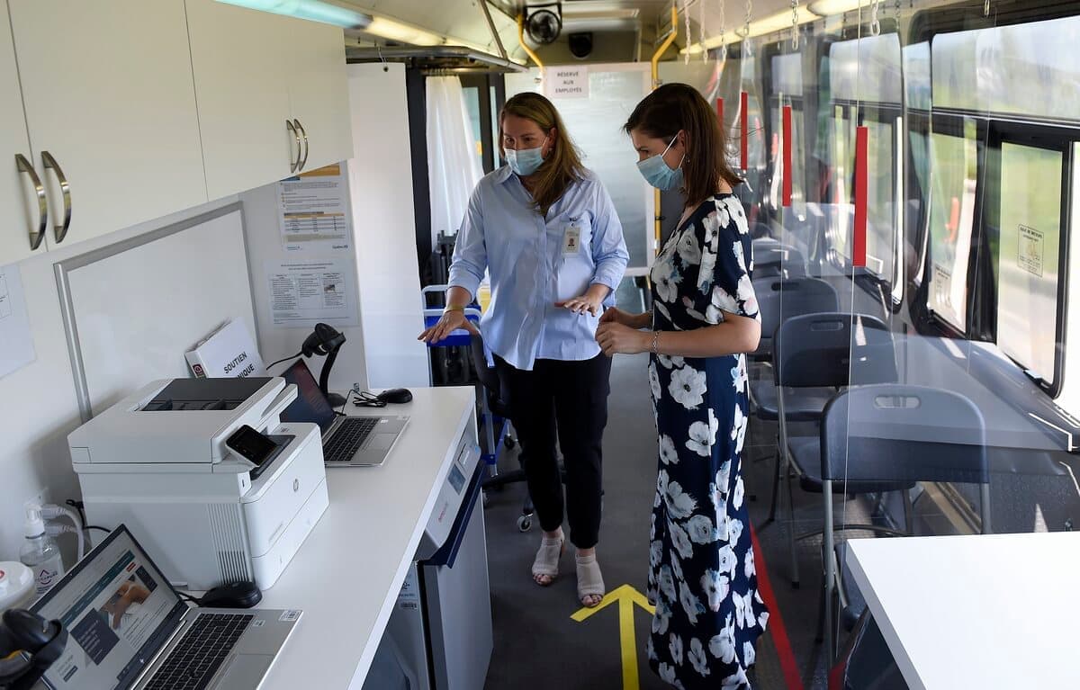 La directrice régionale de la vaccination, Patricia McKinnon (à gauche), a fait visiter le Vaccin-O-Bus flambant neuf à la vice-première ministre du Québec, Geneviève Guilbault, qui a salué l’ingénieuse façon de rejoindre plus de gens.