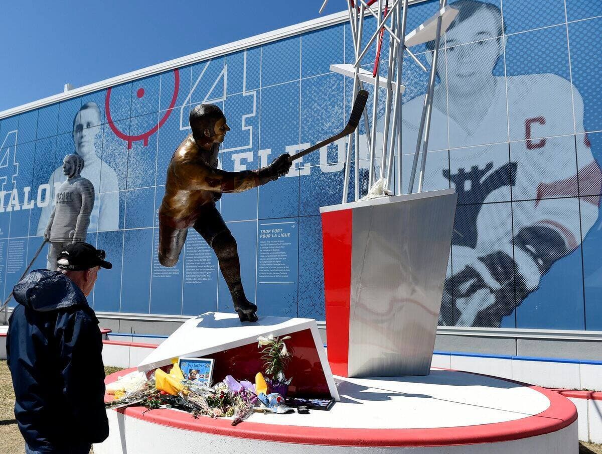 Un homme se recueille devant la statue de Guy Lafleur aussi à place Jean-Béliveau.