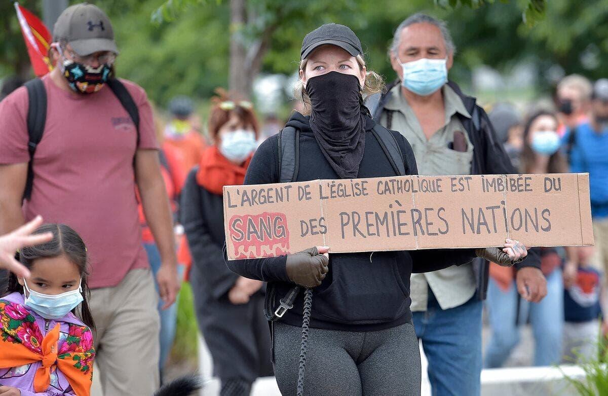 « L’argent de l’Église catholique est imbibé du sang des Premières Nations », pouvait-on lire sur l’affiche de cette femme.