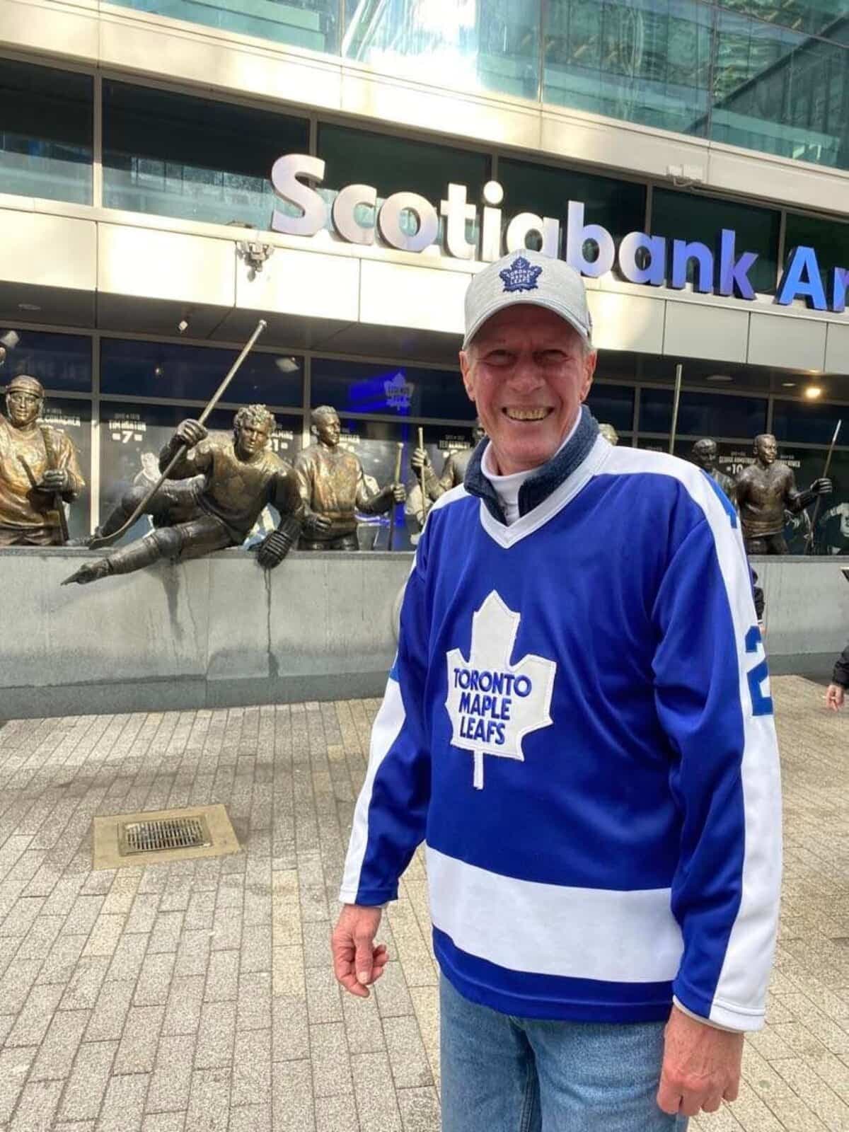 Terry Kingsman, devant les statues du «Legends Row», porte fièrement le même chandail des Leafs aux matchs depuis 45 ans.