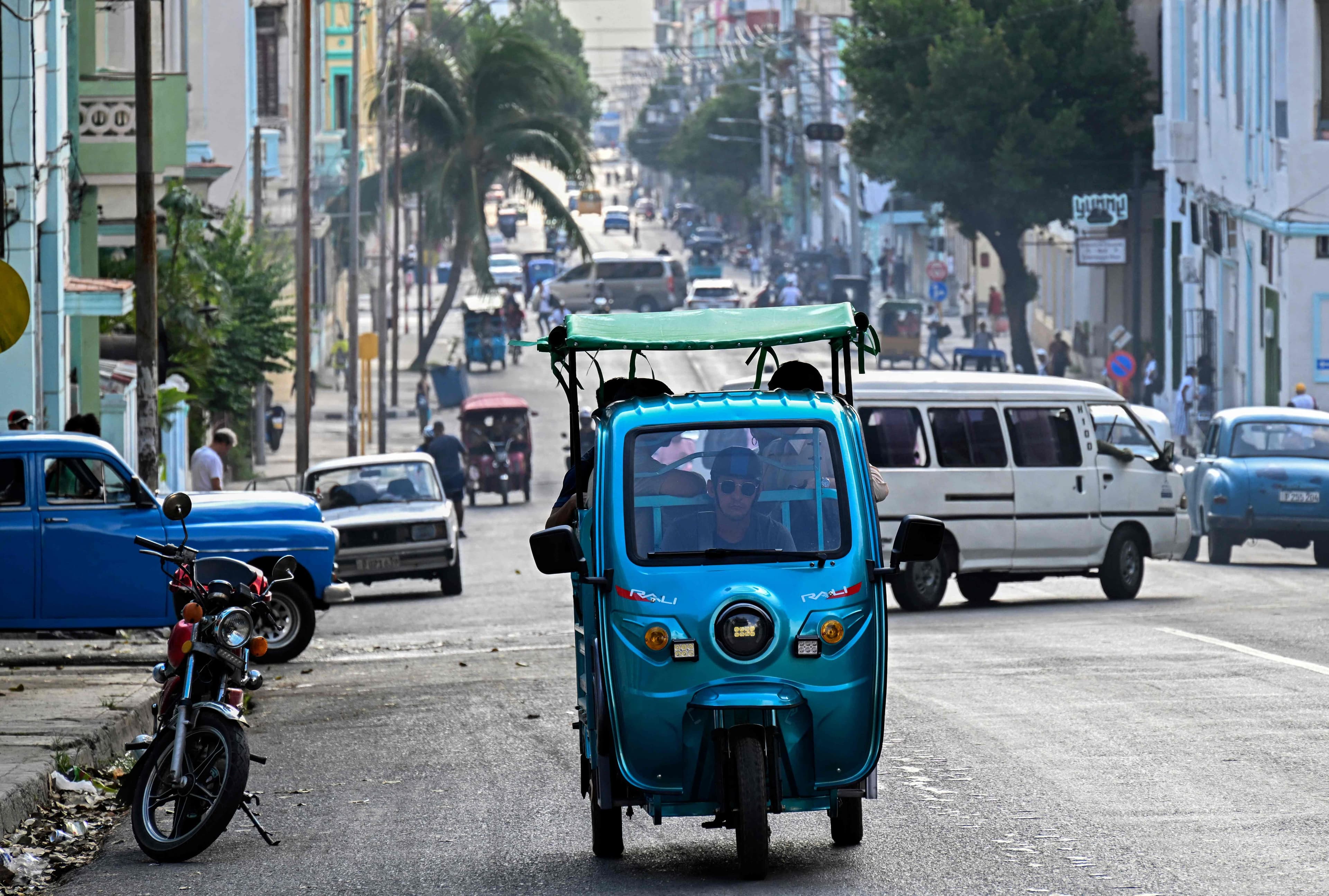 Des personnes circulent à bord d'un tricycle électrique dans une rue de La Havane le 13 mai 2026. Le gouvernement cubain, qui avait autorisé début février les importations privées de carburant pour la première fois en près de 70 ans, a annoncé le 12 mai 2026 qu'il remplacerait le prix de détail fixe du carburant par un prix variable basé sur les coûts d'importation.