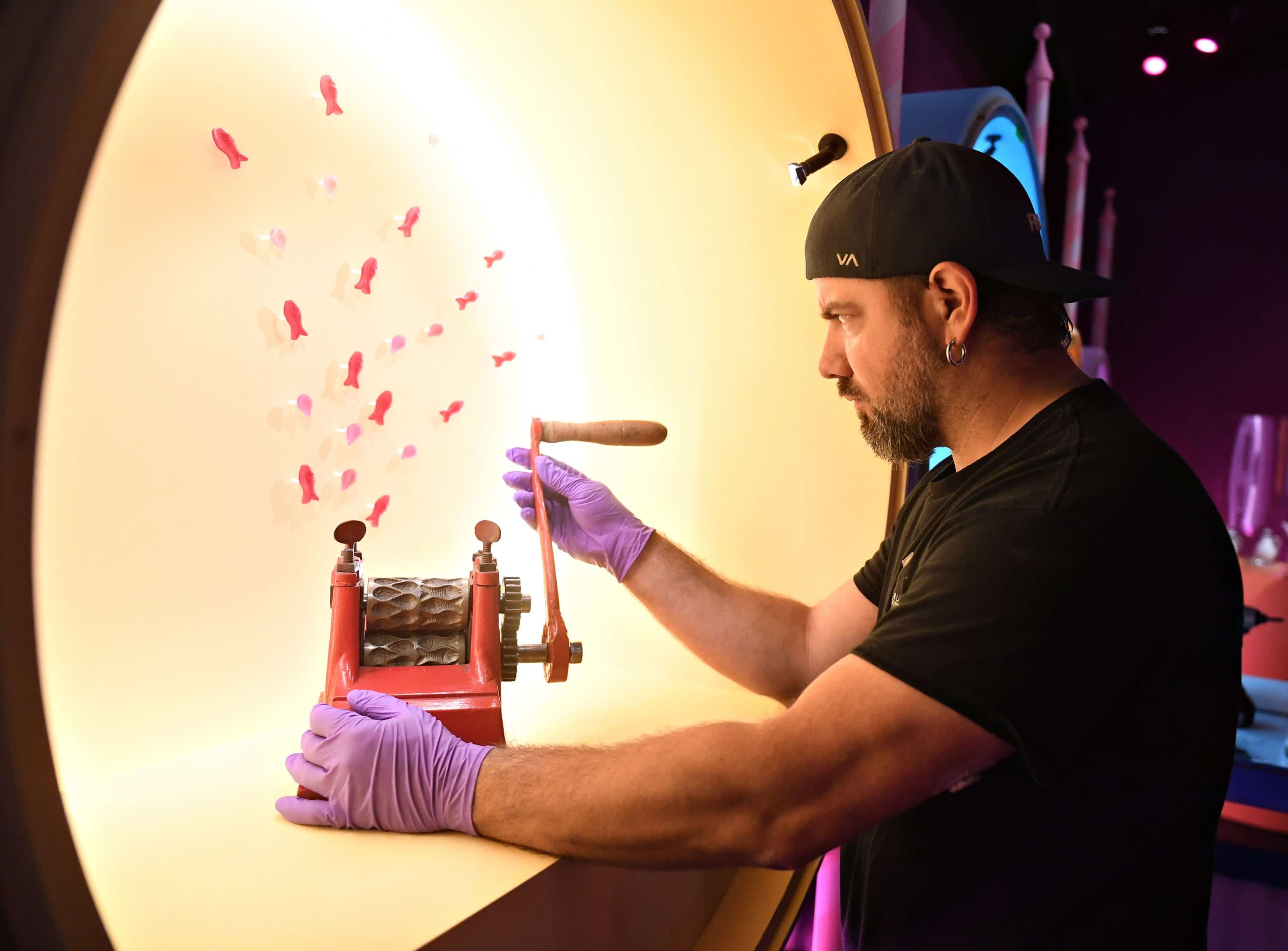 Un employé du Musée de la civilisation dépose une machine à rouler des bonbons dans une vitrine, trois semaines avant l'ouverture de l'exposition « Plaisirs », à l'affiche du 18 juin 2026 au 18 avril 2027.