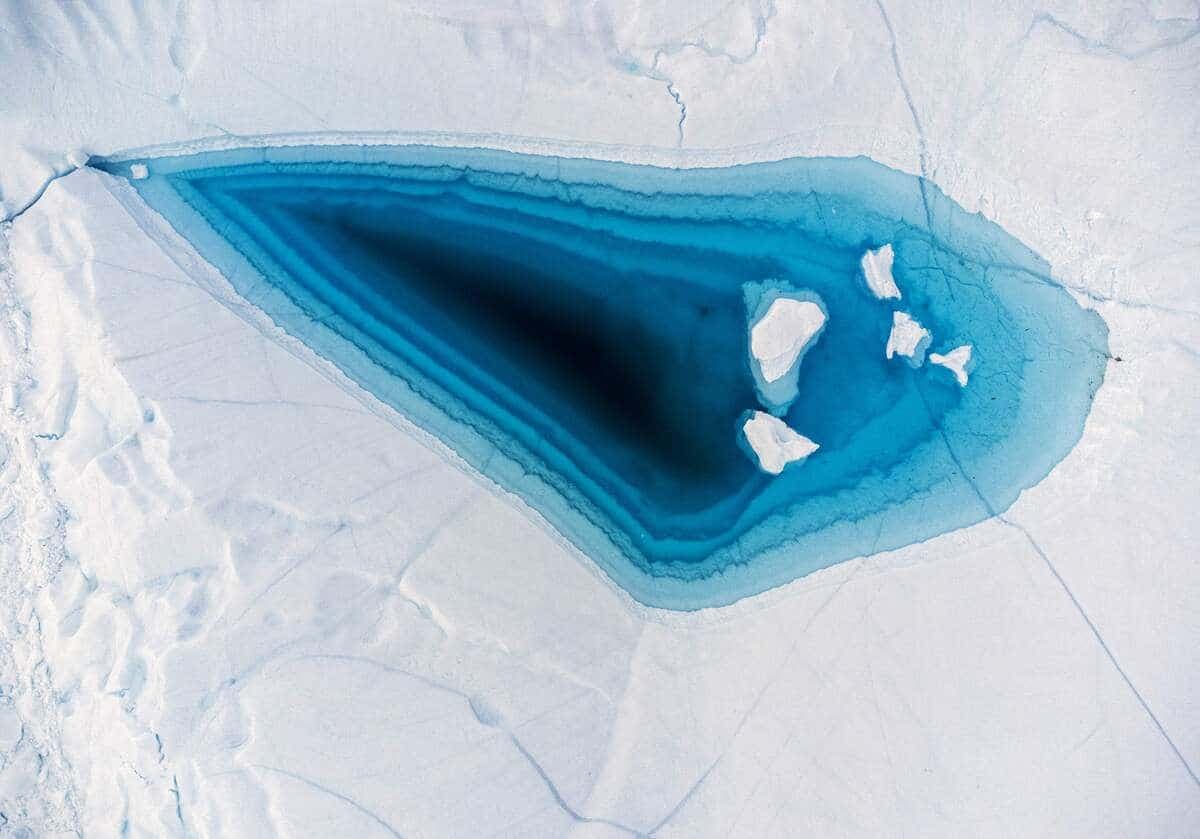 De l'eau turquoise est visible dans un grand trou de fonte au sommet d'un iceberg dans la baie de Disko, à Ilulissat, dans l'ouest du Groenland.