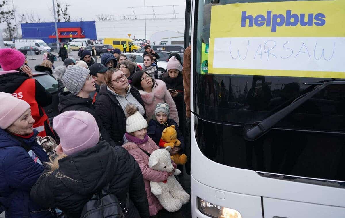 Des réfugiés ukrainiens arrivent par autobus à la frontière afin d'être transférés ailleurs.