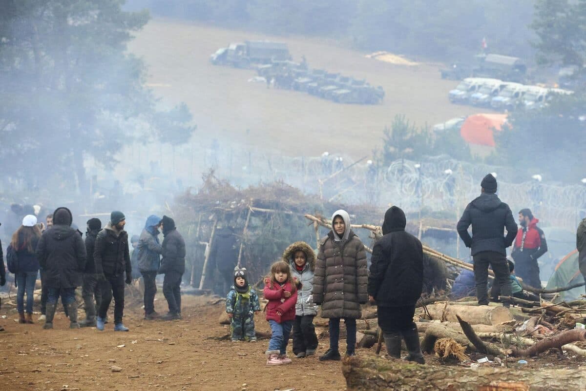 Un groupe de migrants est aperçu dans un camp près de la frontière biélorusse-polonaise dans la région de Grodno le 13 novembre 2021. - Des milliers de migrants - la plupart originaires du Moyen-Orient - ont traversé ou tenté de traverser l'UE et l'OTAN frontière depuis l'été. Les pays occidentaux ont accusé le régime biélorusse, qui est soutenu par la Russie, d'avoir organisé la crise en représailles contre les sanctions de l'UE, accusations que Minsk a démenties.