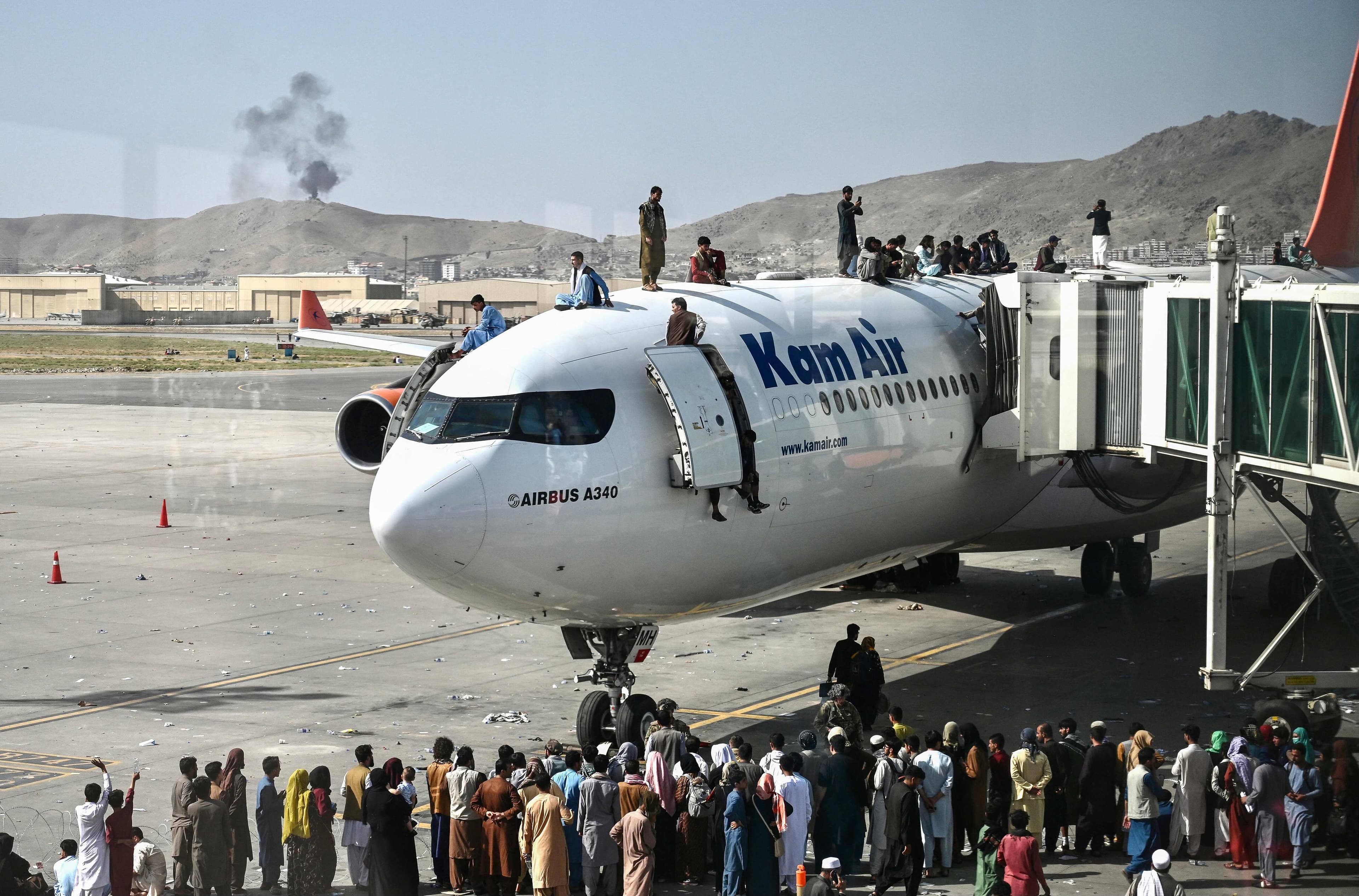 Des personnes attendent sur un avion à l'aéroport de Kaboul dans l'espoir d'être évacuées.