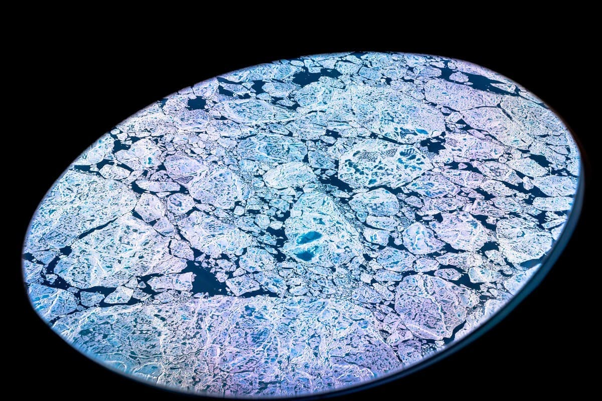 Vue aérienne d'une crêpe de glace et de sa fonte le 19 juillet 2022, prise à bord d’un avion Gulfstream V de la NASA, lors d’une mission aéroportée pour mesurer la fonte de la glace en Arctique.