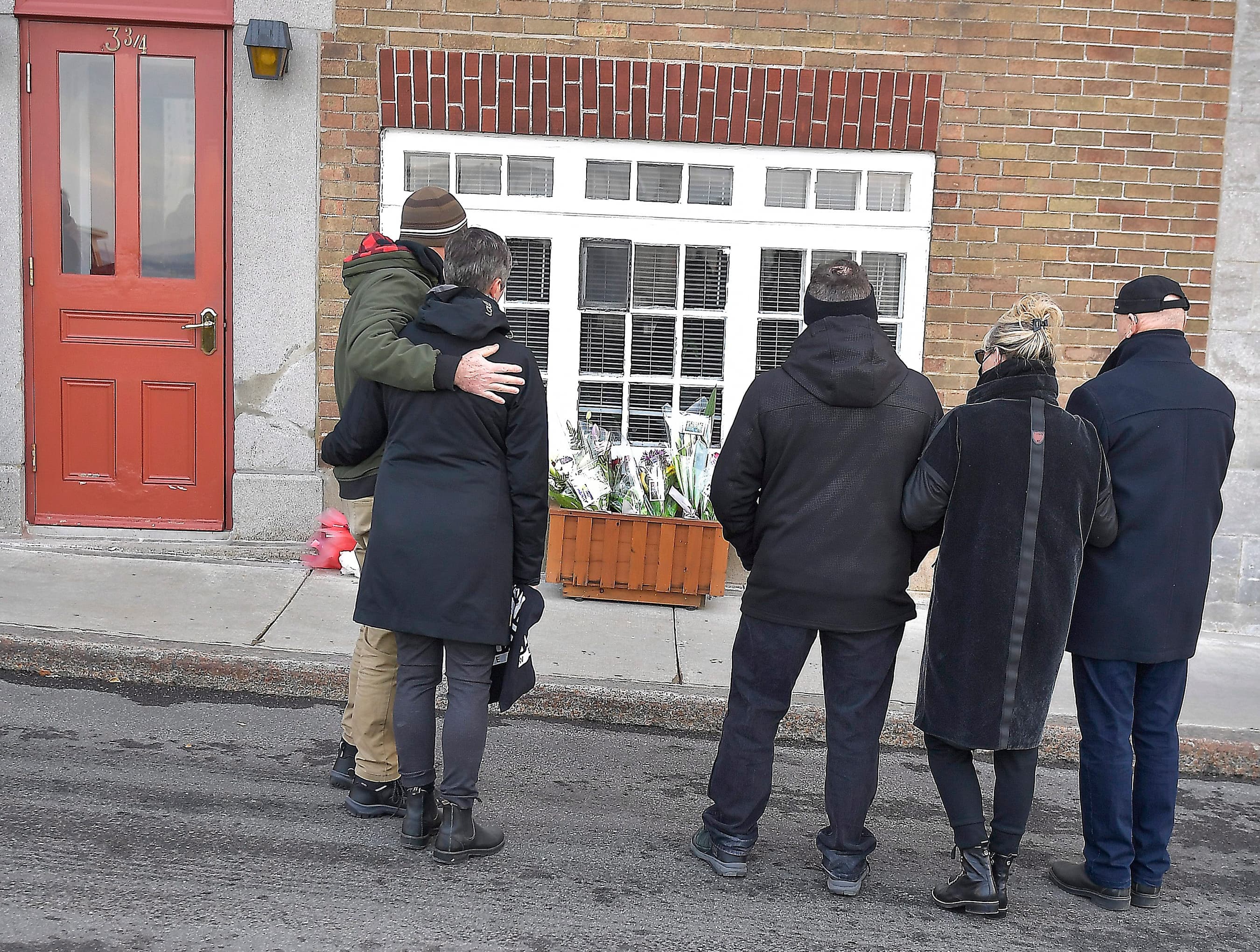 Des proches de Mme Clermont se recueillant devant son domicile.